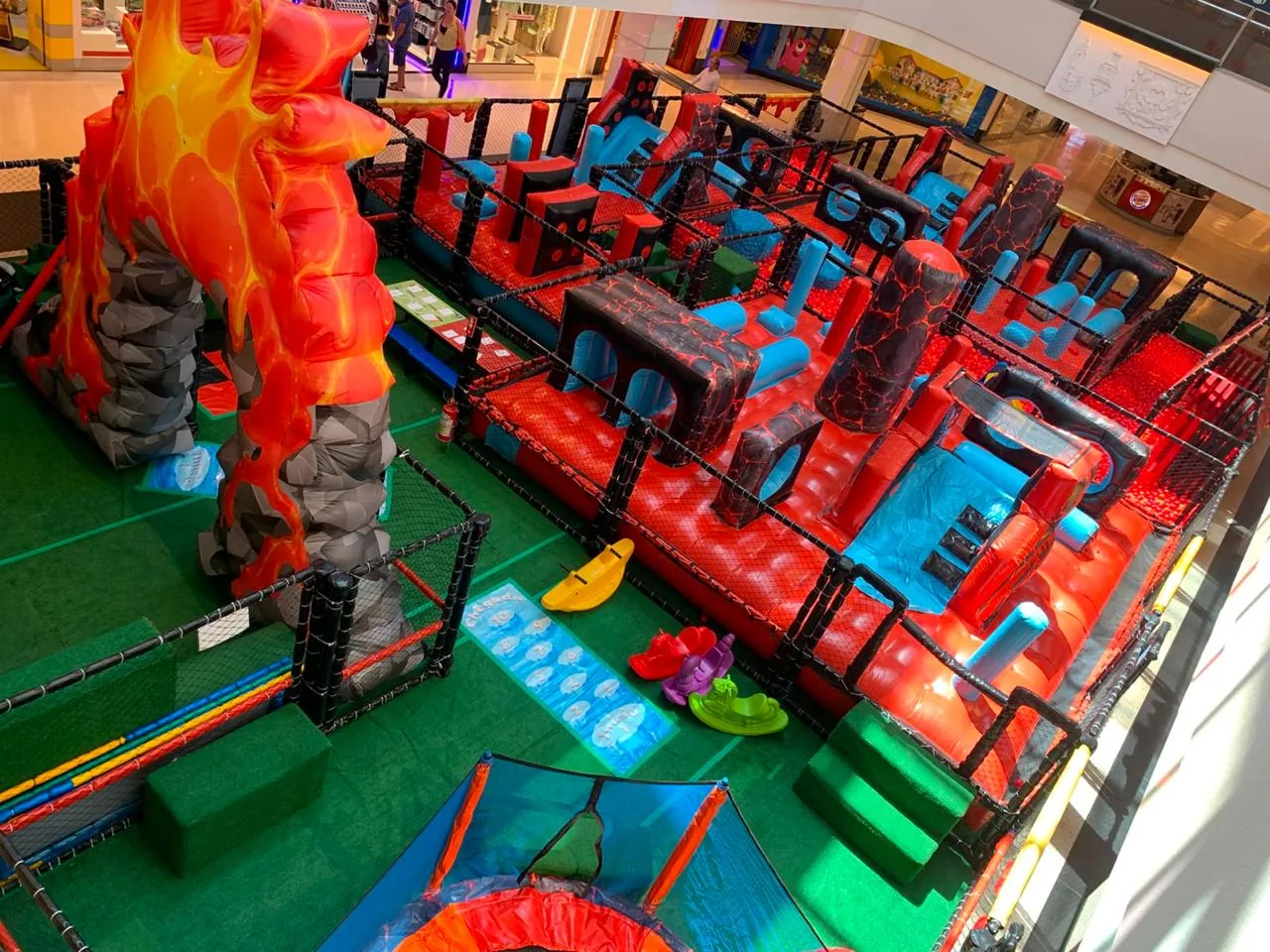 Parque itinerante com tema de aventura e elementos vulcânicos